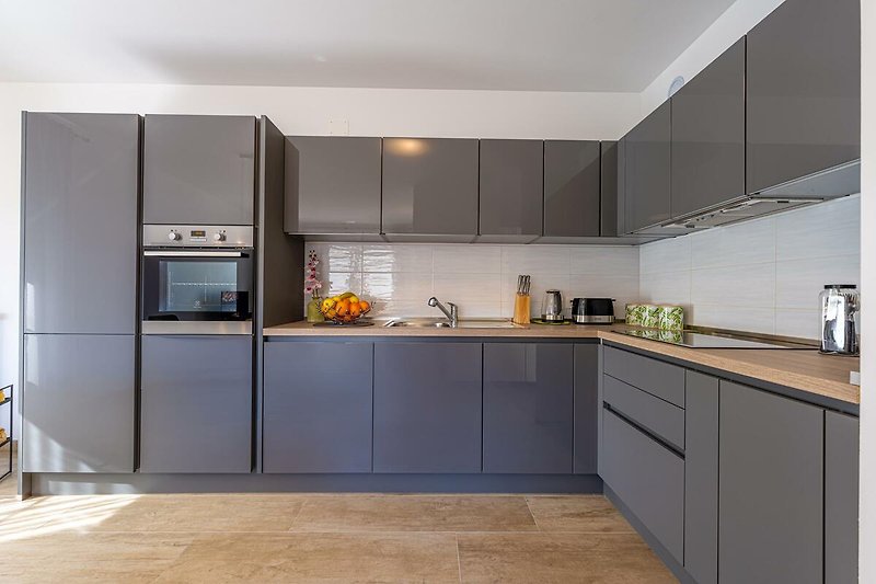 Moderne Küche mit Holzschränken, Granitarbeitsplatte und Edelstahlgeräten.