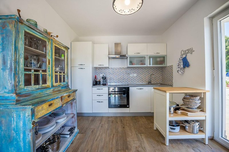 Schöne Küche mit Holzschränken, blauer Arbeitsplatte und stilvoller Beleuchtung.