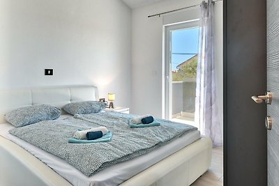Modernes Schlafzimmer mit Holzmöbeln, bequemem Bett und Fensterblick.
