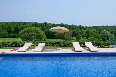 Luxuriöses Ferienhaus mit Pool, Sonnenliegen und Meerblick.