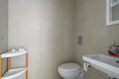 Badezimmer mit modernen Armaturen und Keramikwaschbecken.