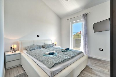 Schlafzimmer mit bequemem Bett, Holzmöbeln und Fenster.