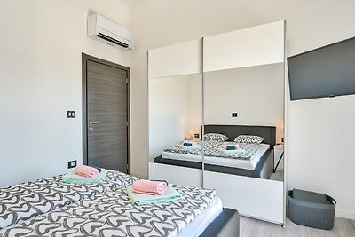 Modernes Schlafzimmer mit gemütlichem Bett, Holzmöbeln und Fensterblick.