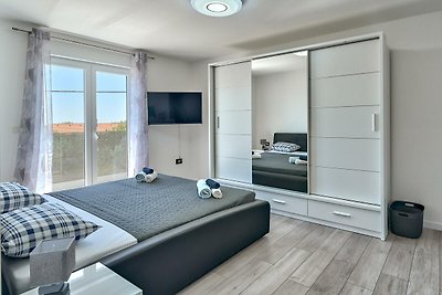 Modernes Schlafzimmer mit Holzmöbeln, bequemem Bett und Vorhängen.