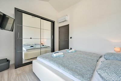 Modernes Schlafzimmer mit bequemem Bett, Holzmöbeln und Fensterblick.