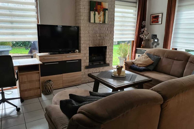 Blick auf das Wohnzimmer mit Innenkamin und Fernseher