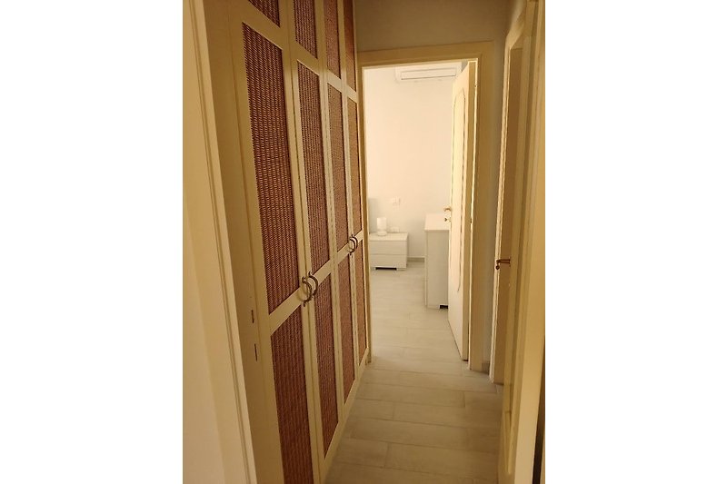 Elegante porta in legno con maniglia metallica e dettagli in legno.