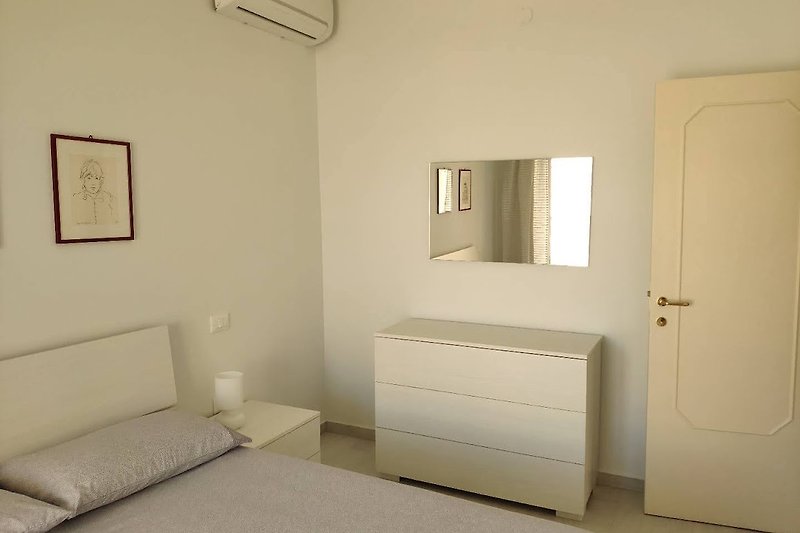 Camera da letto accogliente con letto in legno e armadio.