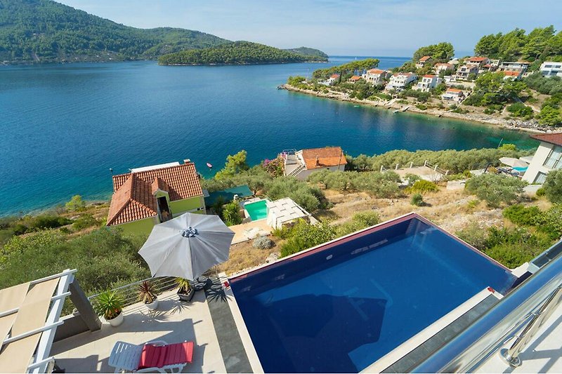 Luxuriöse Villa am See mit Pool und atemberaubendem Bergblick.