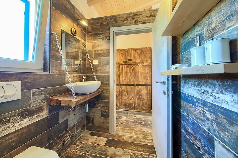 Ein modernes Badezimmer mit stilvoller Einrichtung und elegantem Spiegel.
