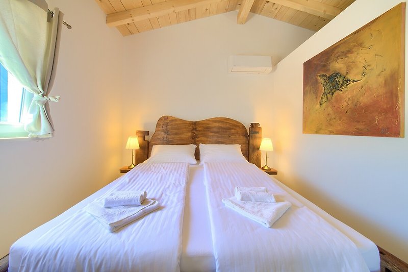 Gemütliches Schlafzimmer mit stilvoller Beleuchtung und Holzbett.