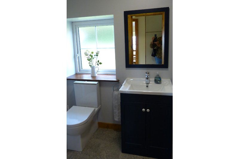 Schönes Badezimmer mit Spiegel, Waschtisch und Armatur.