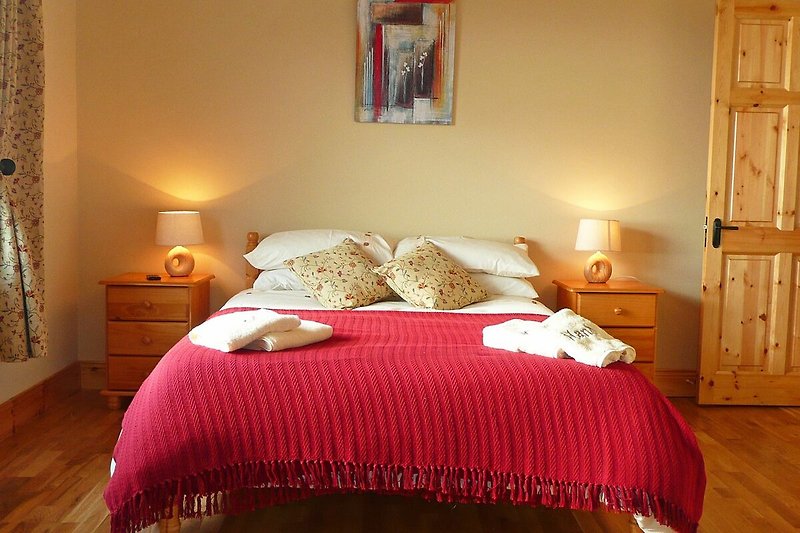 Holzinterieur mit gemütlichem Bett und stilvoller Beleuchtung.
