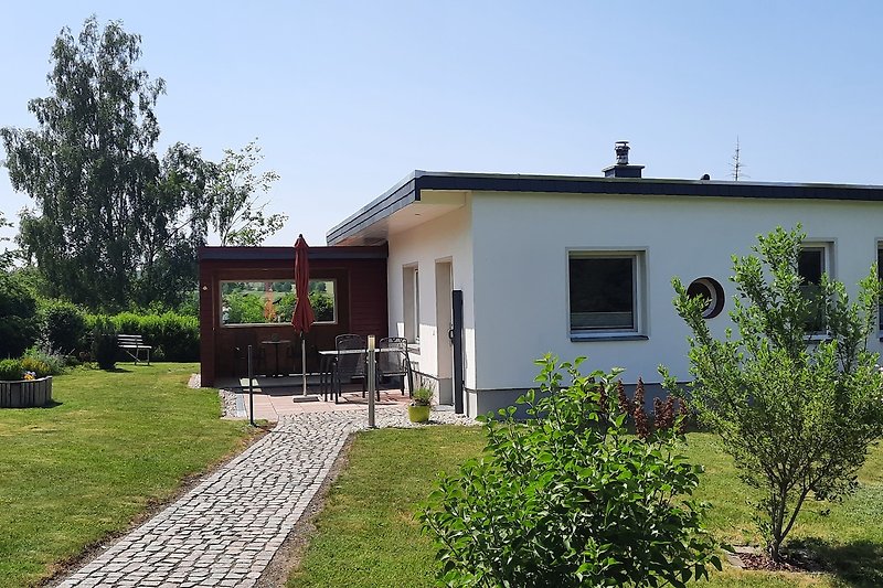 Großer Garten mit gepflegtem Rasen und schattigem Bereich.