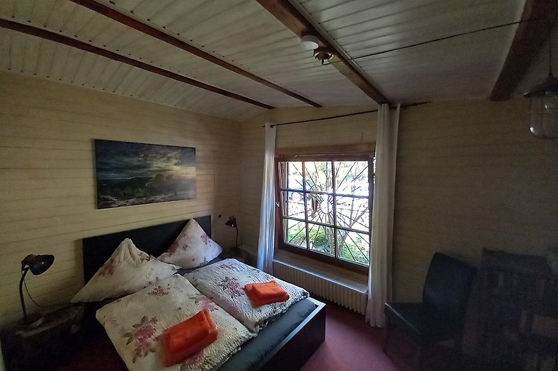 Ihr gemütliches Schlafzimmer 1 mit Zugang zum eigenen Bad und Blick in den Wald