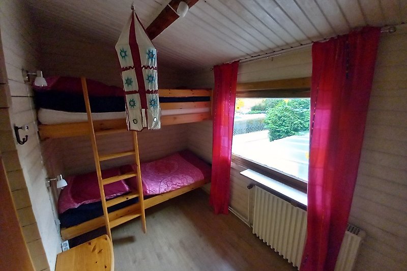 Gemütliches Schlafzimmer für Kinder mit Etagenbett und Fensterblick