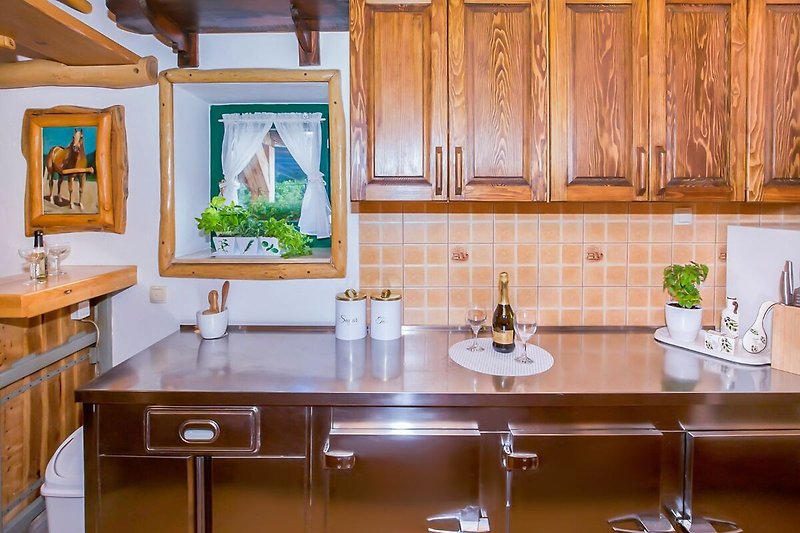 Moderner Küchenbereich mit Holzelementen und hochwertiger Ausstattung.