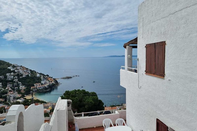 Villa am Meer mit Balkon, Holzmöbeln und atemberaubendem Ozeanblick.