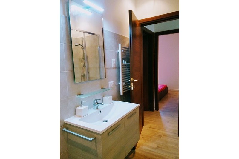 Lila Badezimmer mit Spiegel, Waschbecken und lila Duschvorhang.