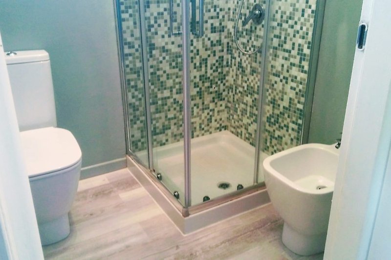Badezimmer mit lila Duschvorhang und Glasdusche.