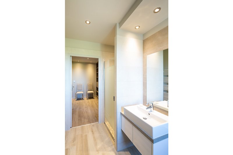 Modernes Badezimmer mit elegantem Design und Spiegel.