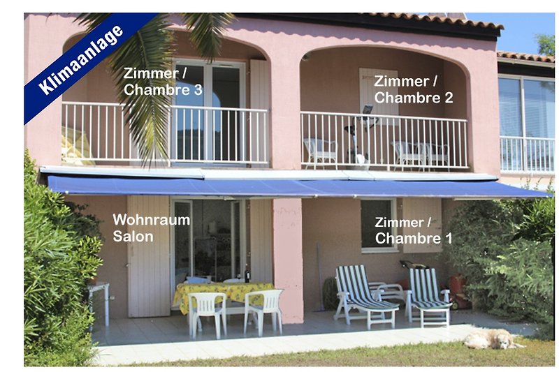 Schönes Ferienhaus mit Terrassenöbeln, Tisch, Stühlen und Liegen  auf der Veranda.