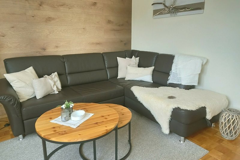 Gemütliches Wohnzimmer mit bequemer Couch, Holzmöbeln und stilvollem Interieur.