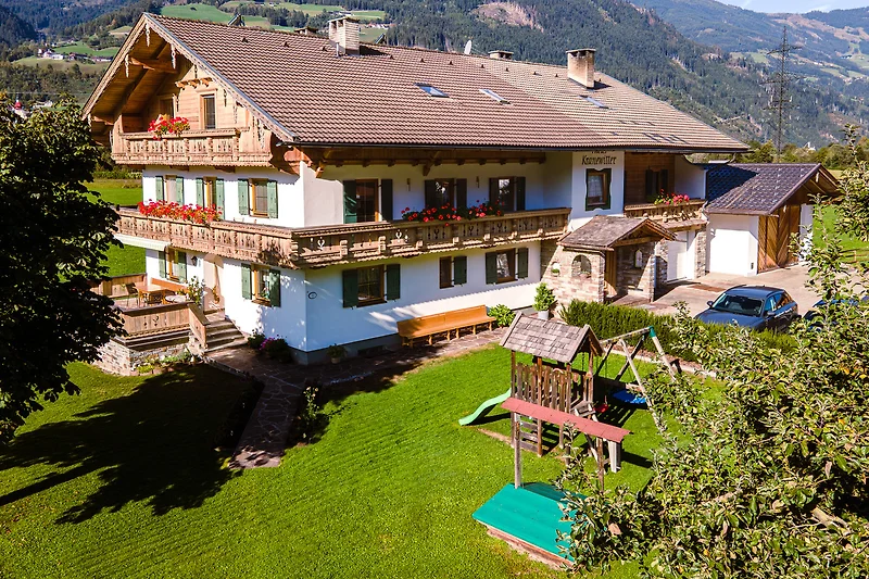 Ländliches Ferienhaus mit rotem Dach und grünem Garten.