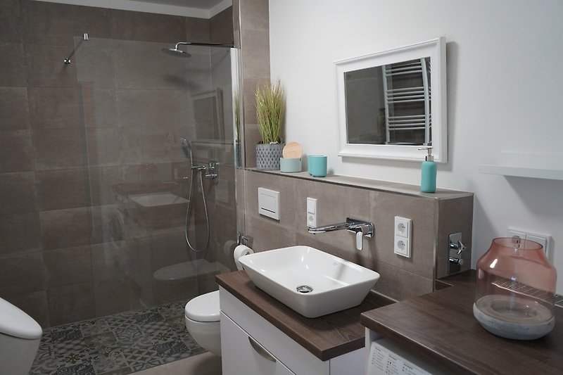 Salle de bain avec douche à effet de pluie, urinoir et machine à laver
