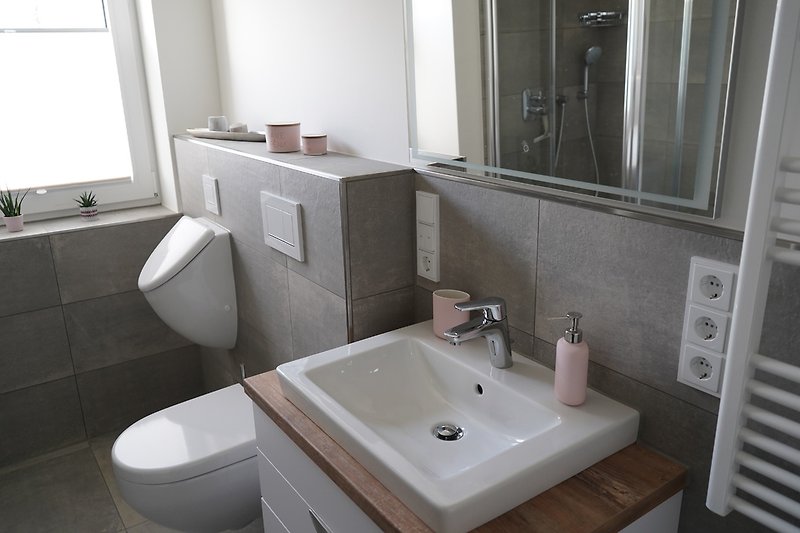 Badezimmer mit Regendusche, Urinal und Infrarotkabine