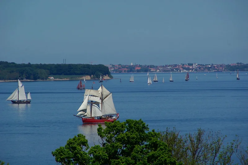 Segelboote und Yachten auf dem Wasser vor beeindruckender Küstenkulisse