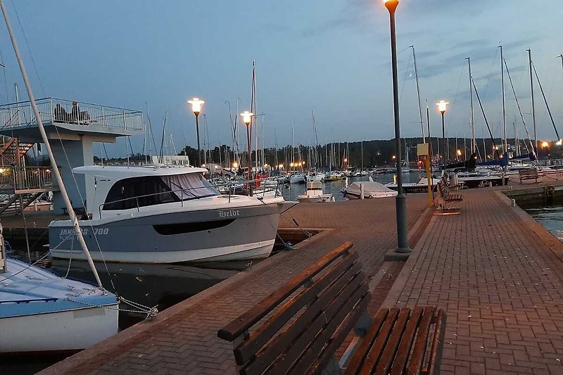Boote und Hafen bei Nacht in der Stadt am Meer.
