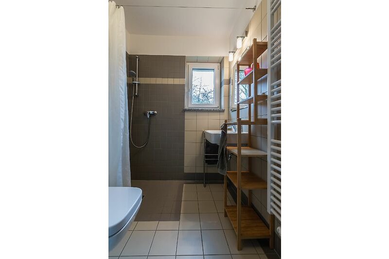 Die baugleichen Bäder auf beiden Etagen haben eine bodengleiche Dusche, Waschbecken und WC und viel Ablagefläche.