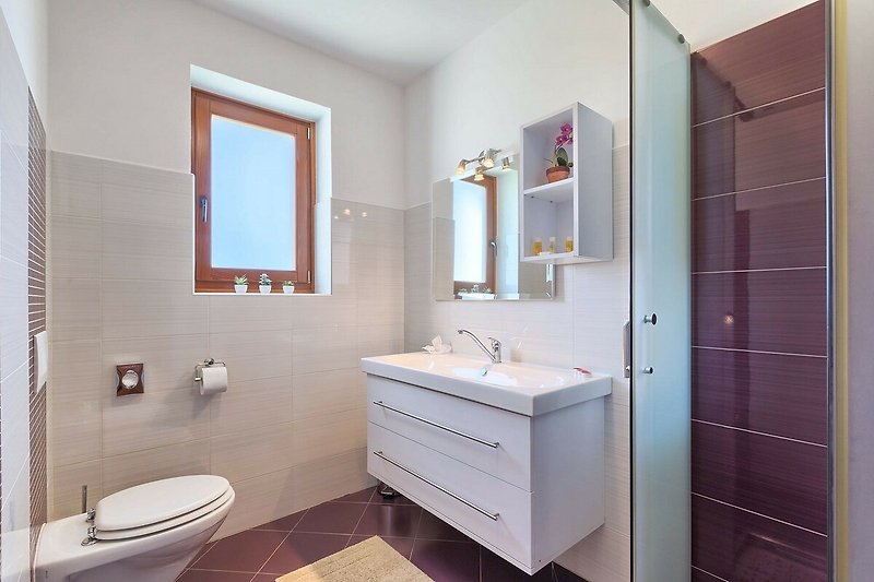Predivan interijer kupaonice s lijepim namještajem i modernim umivaonikom.
