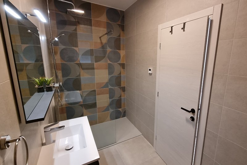 Modernes Badezimmer mit stilvoller Dusche und Spiegel.