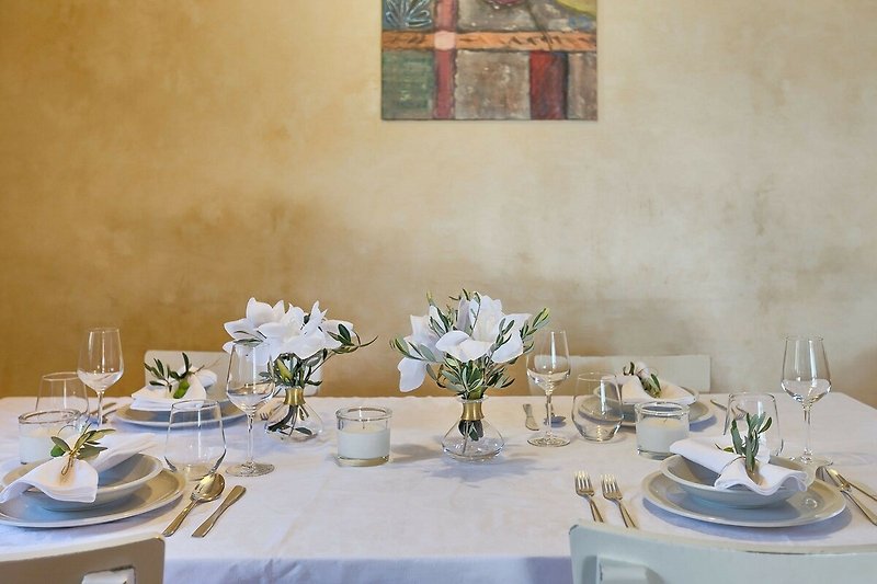 Prekrasan stol s cvijećem, dekoracijom i elegantnim posuđem.
