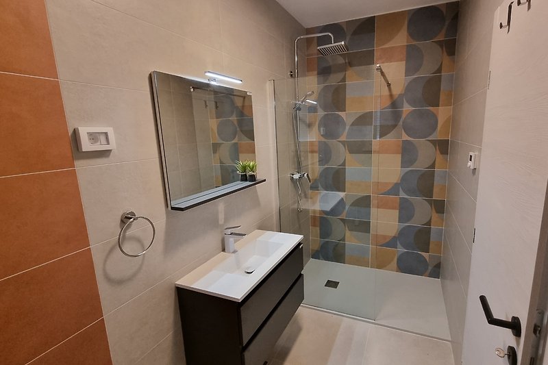 Modernes Badezimmer mit stilvoller Dusche und Waschbecken.