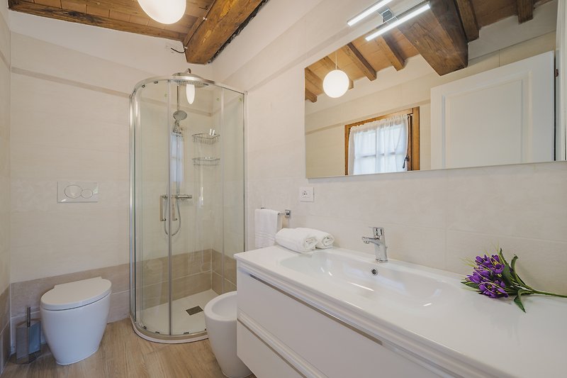 Modernes Badezimmer mit lila Akzenten, Dusche, Badewanne und Spiegel.
