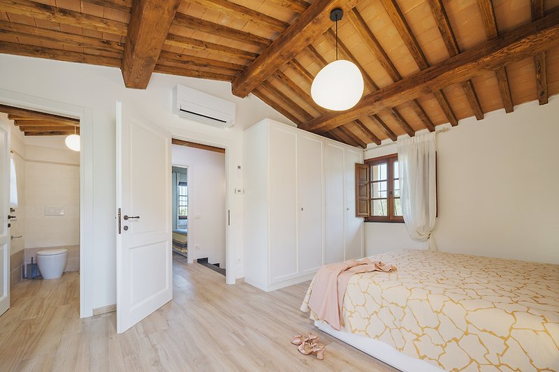 Geräumiger Dachboden mit Holzbalken und gemütlicher Einrichtung.