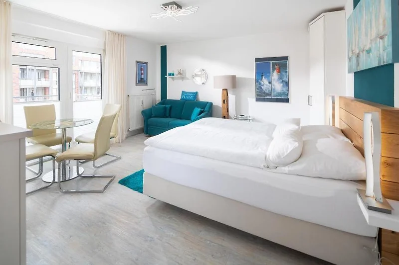 Komfortables Schlafzimmer mit großem Bett, Sessel und sanfter Beleuchtung.