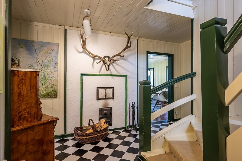 Gemütliches Wohnzimmer mit Holzboden und Kunstwerken an den Wänden.