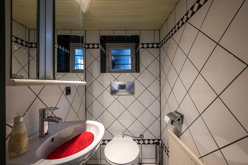 Gemütliches Badezimmer mit stilvoller Fliesendesign und moderner Armatur.