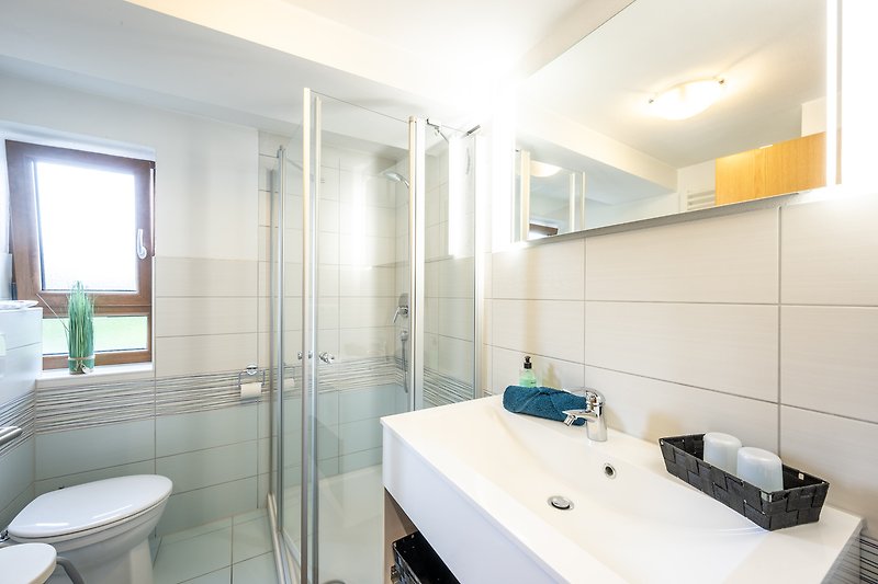 Modernes Badezimmer mit stilvoller Ausstattung und hellem Tageslicht.