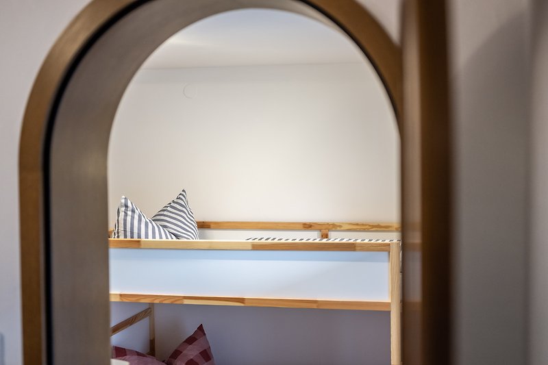 Gemütliches Zimmer mit Holzfenster, stilvoller Beleuchtung und gemütlichem Holzmöbel.