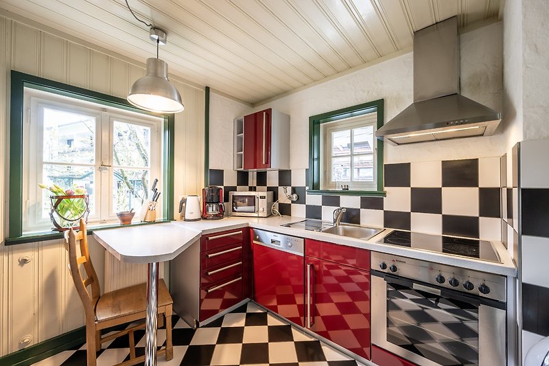 Gemütliche Küche mit Holzschränken, Arbeitsplatte und Fenster.