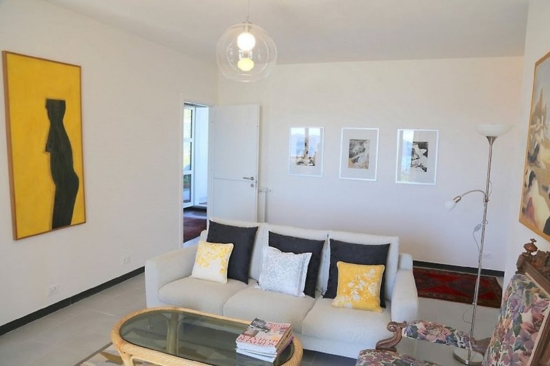 Wohnzimmer mit moderner Einrichtung, gemütlicher Beleuchtung und Kunst.