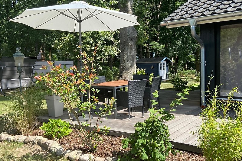 Grosszügige Terrasse mit Gartenmöbeln und Sonnenschirm
