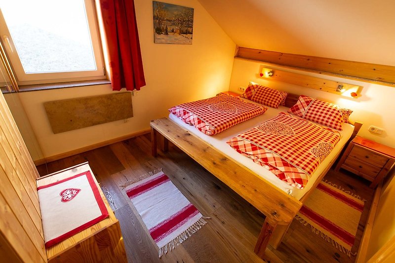 Ein gemütliches Schlafzimmer mit Holzmöbeln und orange-gestaltetem Bettzeug.