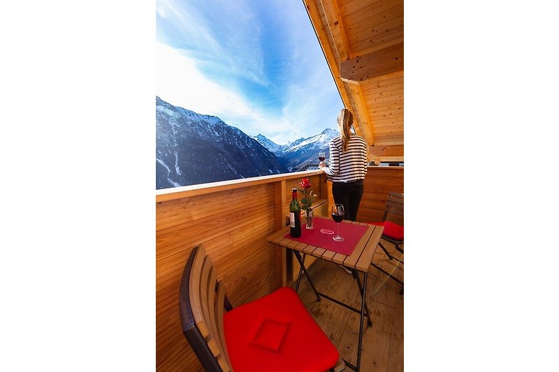 Holzstühle und Tisch im Freien mit Bergblick.