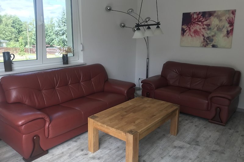 Gemütliches Wohnzimmer mit bequemer Couch, Holztisch und Pflanzen.